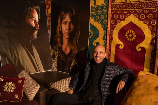 The New York City-based costume designer Luca Mosca, beside photos of Keanu Reeves and Halle Berry, whom he dressed for the latest John Wick flick.